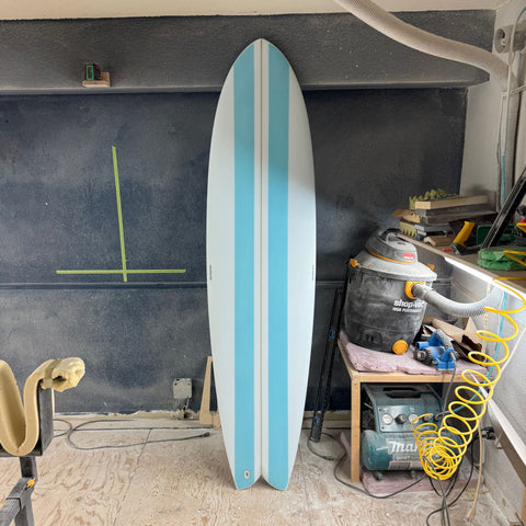 "Alchimie Surf Longfish 7'0'' surfboard front view – light blue stripes, versatile mid-length"