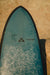 A midlenght alchimie surfboard in daylight.